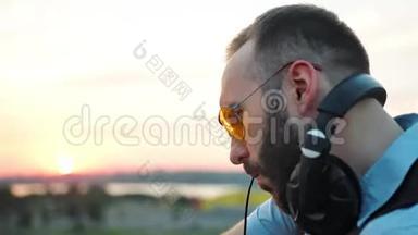 夏季屋顶派对中，带耳机和太阳镜的流行DJ简介